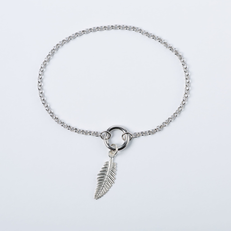 Zestaw srebrna bransoletka z zawieszką w kształcie gałązki.