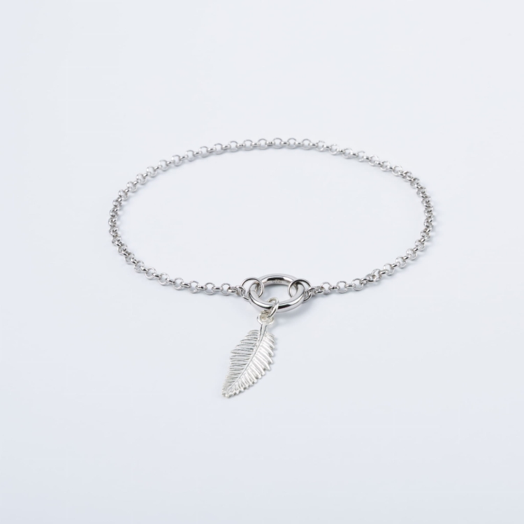 Zestaw srebrna bransoletka z zawieszką w kształcie gałązki.